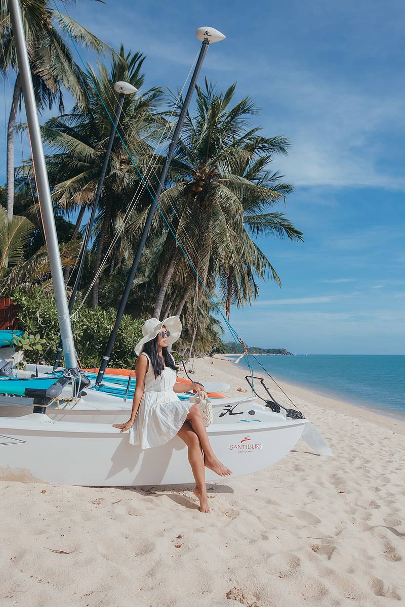 Channa sitz aiuf einem Boot am Strand des 5 Sterne Resorts Santiburi am Maneam Beach Koh Samui