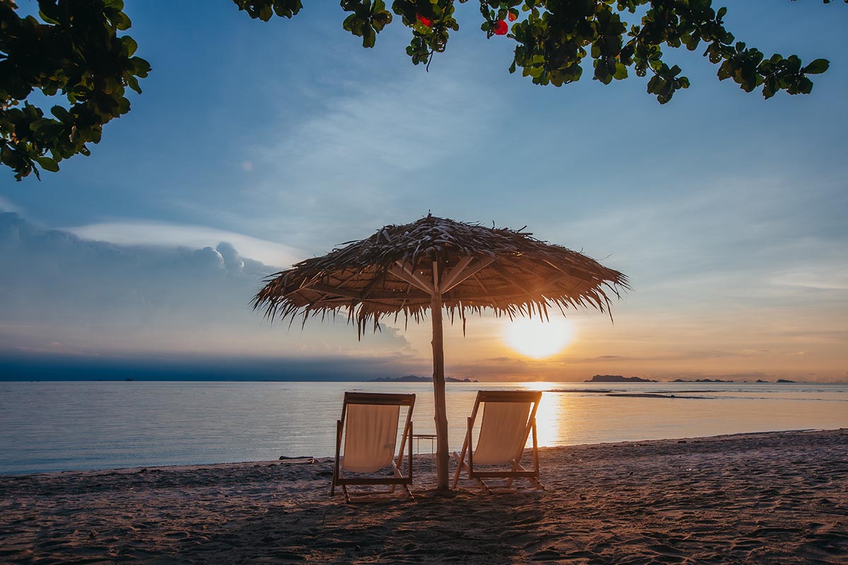 Die Sonner versinkt langsam am Horizont. Sonnenschirm am Nathon Beach Samui