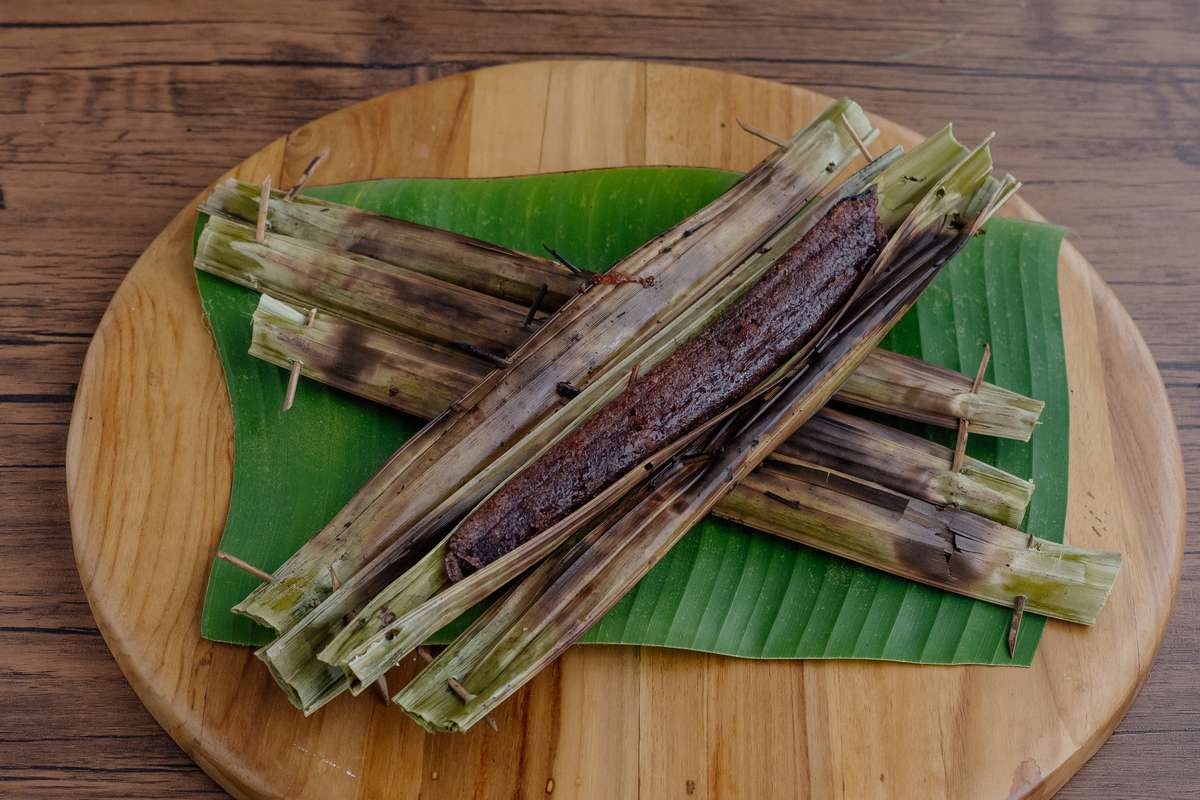 Das traditionelle Kanom Jak (ขนมจาก) Dessert in Palmblättern gewickelt und auf einem Bananenblatt platziert