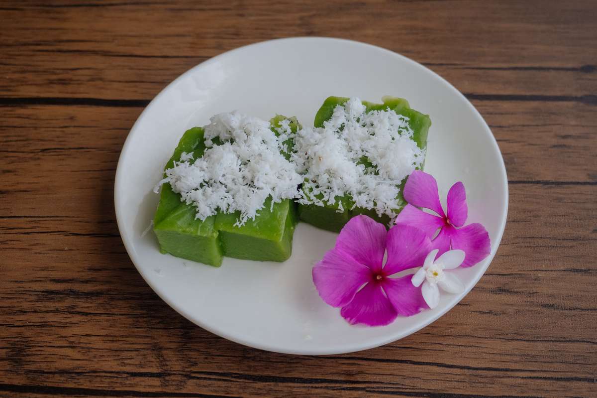 Das grüne Thai Dessert Khanom Piak Poon (ขนมเปียกปูน) hier mit Kokosraspeln bestreut und einer Blume dekoriert  