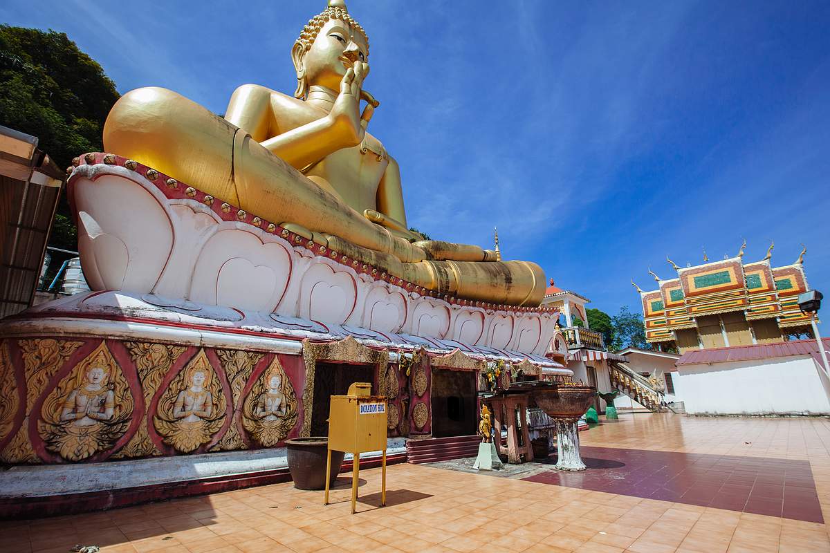 Ein goldenenet Tempel schimmert in der Morgensonne. Phuket bei bestem Reisewetter.