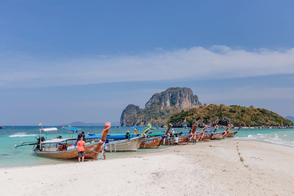 Der Strand von Chicken Island mit traditionellen Longtail Booten