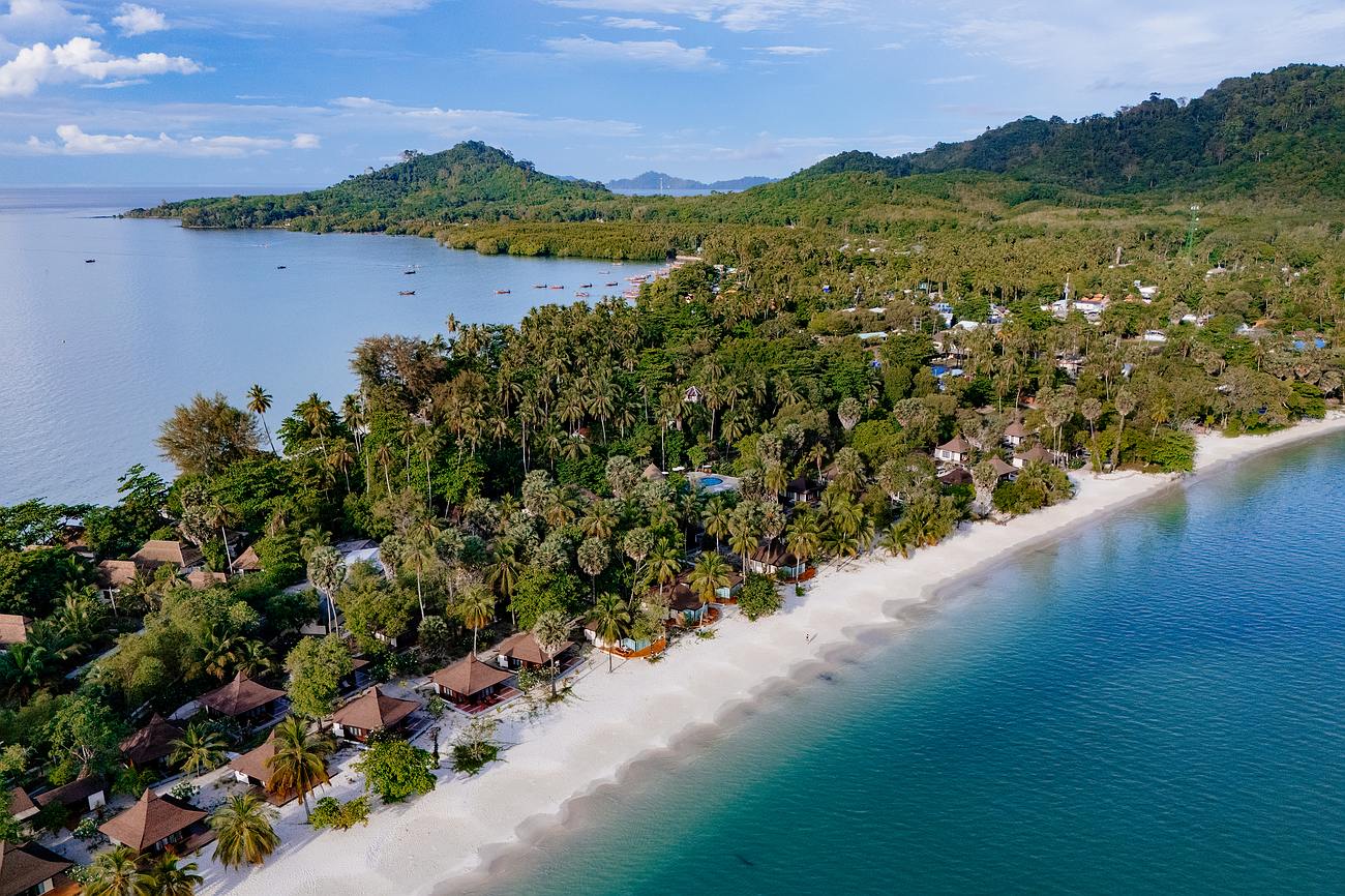 Palmen, weisser Sand und strahlend blaues Meer am Strand Koh Mook