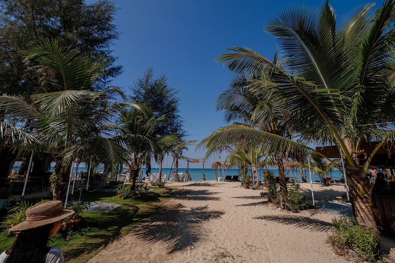 Ruhiger Sandstrand in Khao Lak mit Palmen und Liegen – trockenes, warmes Wetter ideal zum Entspannen