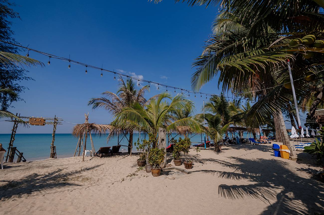 Tropischer Strand in Khao Lak mit Palmen und blauem Himmel – ideales Wetter in der Trockenzeit mit viel Sonne