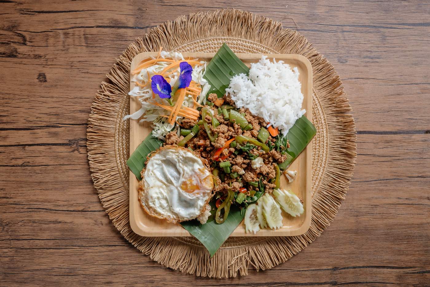 Pad Kra Pao serviert mit Reis und Spiegelei